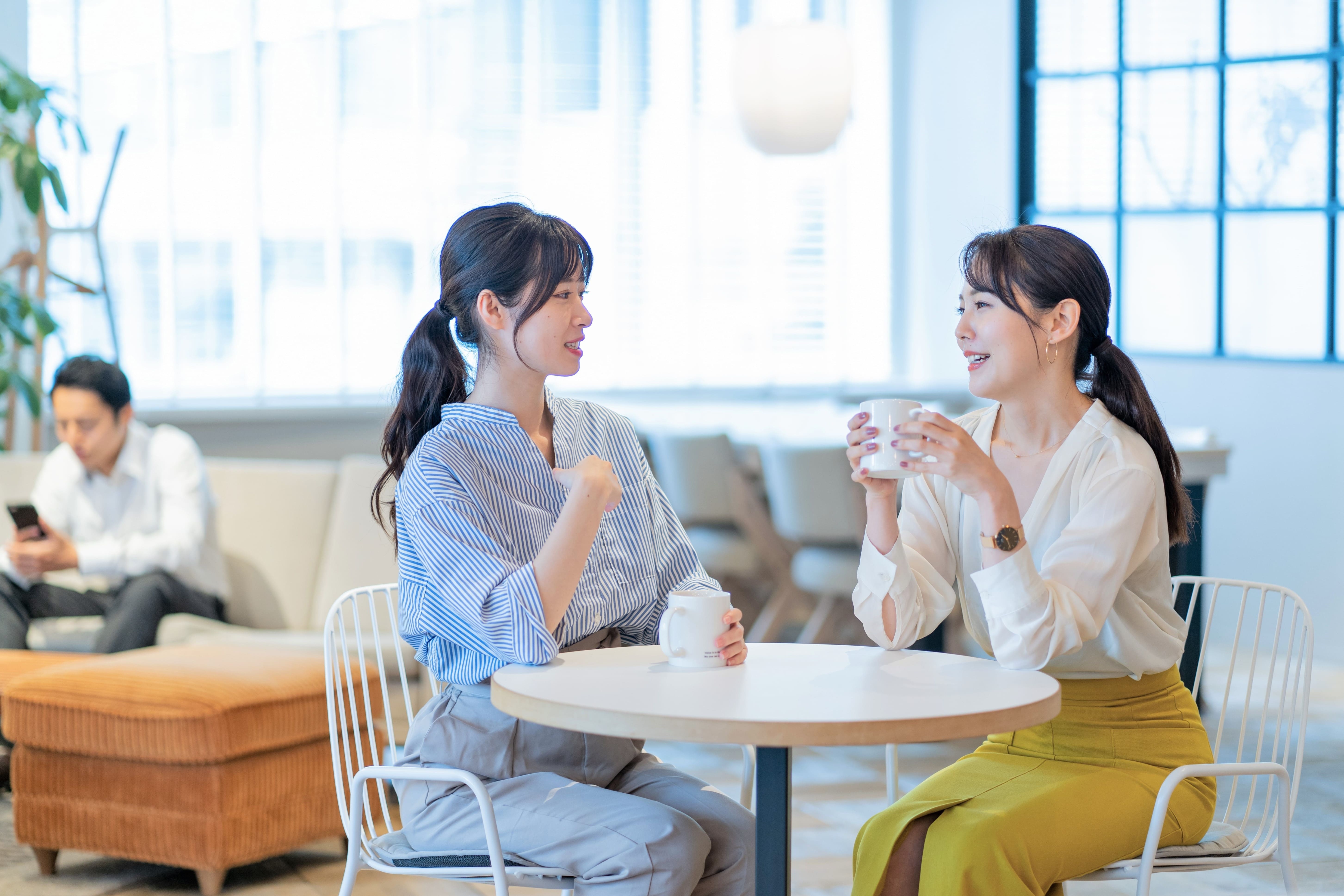 オフィスに設置されたカフェスペースでコーヒーを楽しみながらコミュニケーションを取る様子