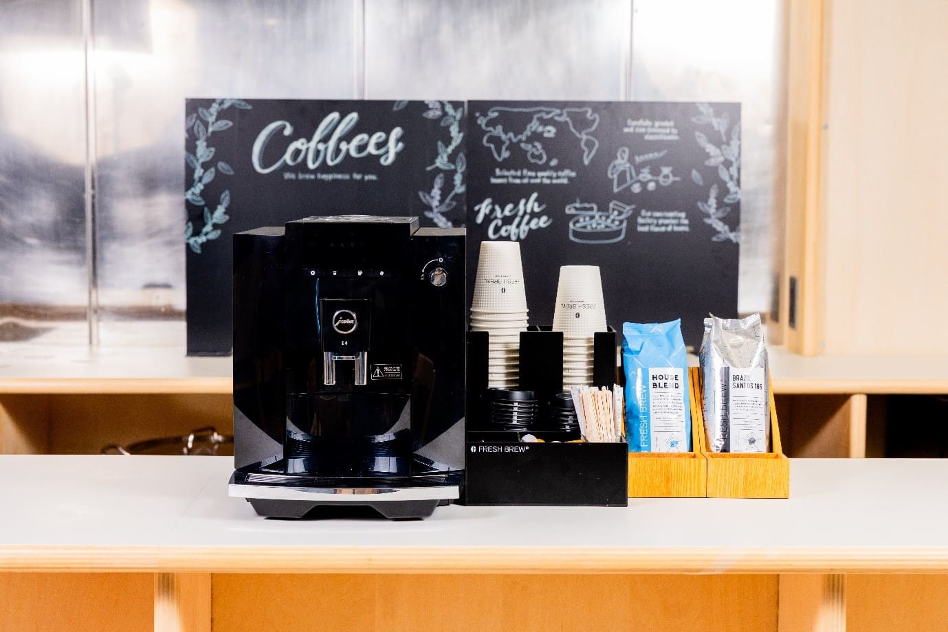 小規模オフィスカウンターに設置されたjura製コーヒーマシンとカフェ風セットアップ